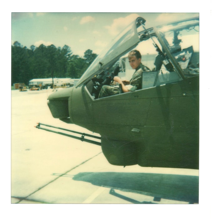Pilot seated in helicopter cockpit on the tarmac
