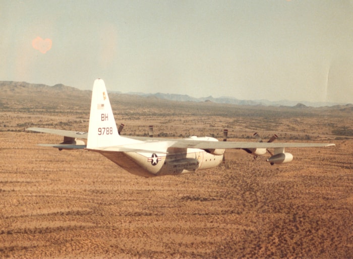 KC-130 flying low over desert terrain